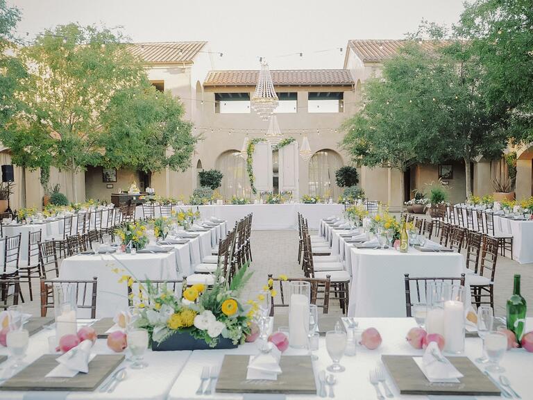 An outdoor reception with chandeliers and ranunculus