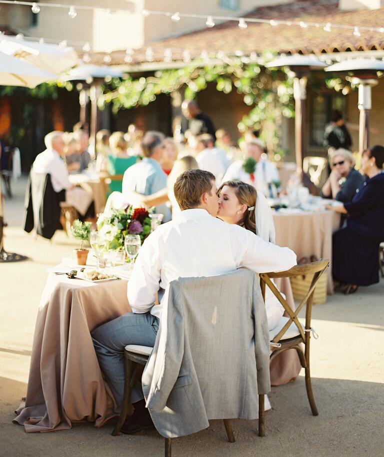 Newlyweds sit at their sweetheart table at their reception