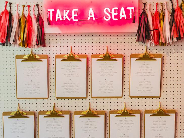 Seating arrangements are found on clipboards on a bright wall