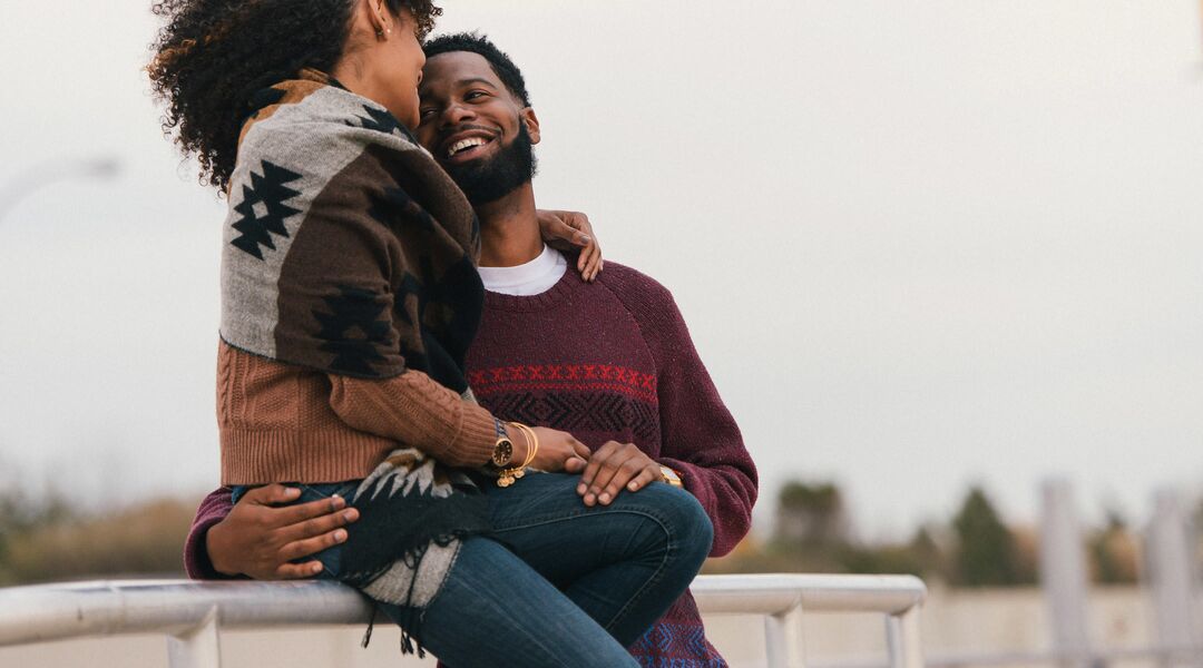 African American couple embracing outside.