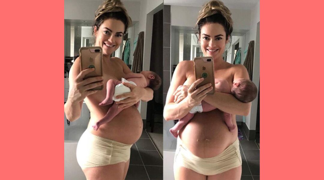 Pregnant woman taking postpartum mirror selfie while holding her newborn 