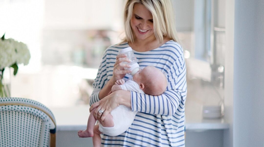 Natalie Thomas formula feeding her newborn baby at home