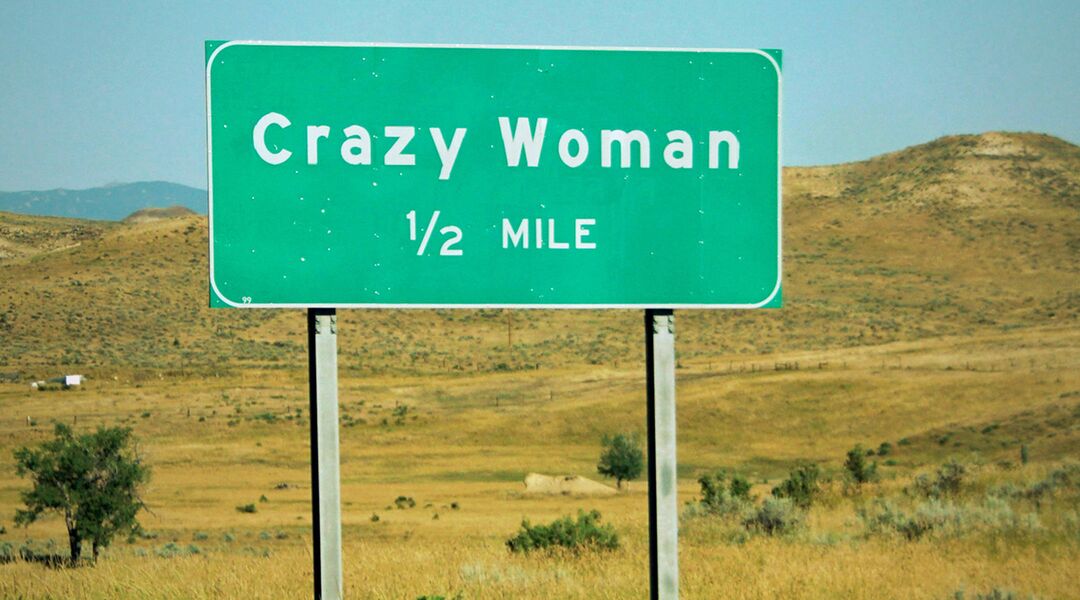 highway sign says crazy woman half mile