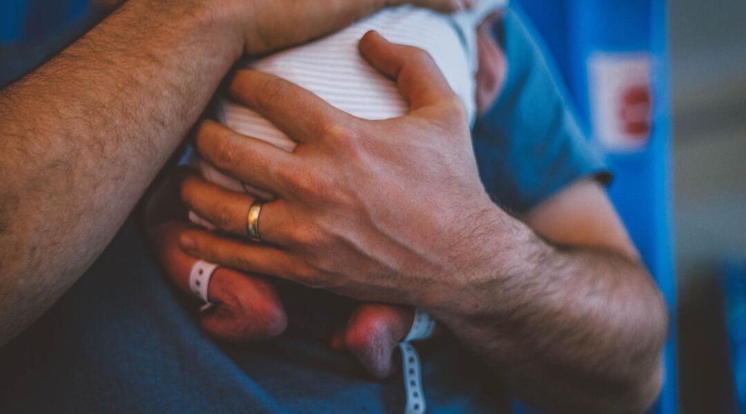 father holding newborn son in hospital