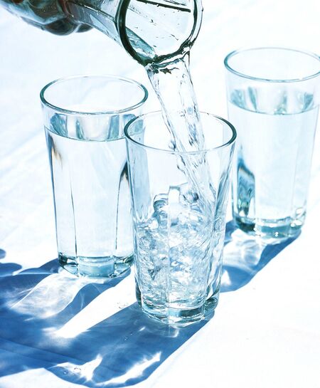 Woman drinking water from bottle and pours water on her breasts and  stomach. Thirsty Girl in