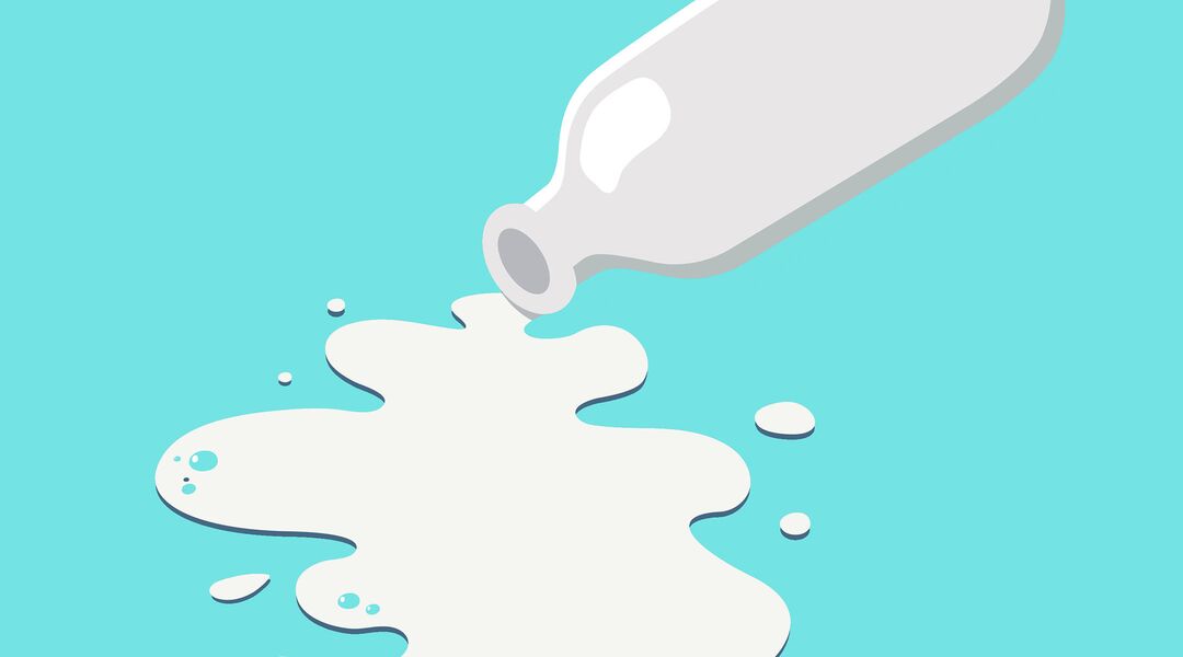 Bottle of milk with milk spilling out