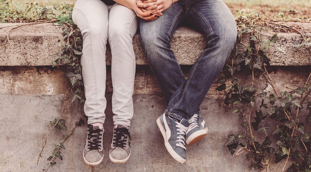 couple sitting holding hands discussing