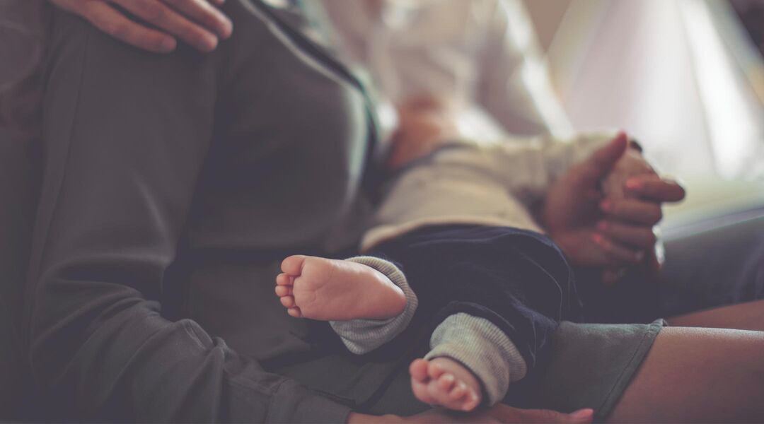 baby's feet pictured during breastfeeding