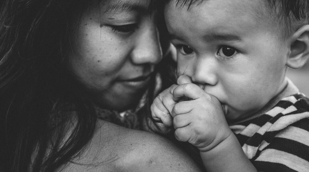 Black and white close up of mom holding baby son. 