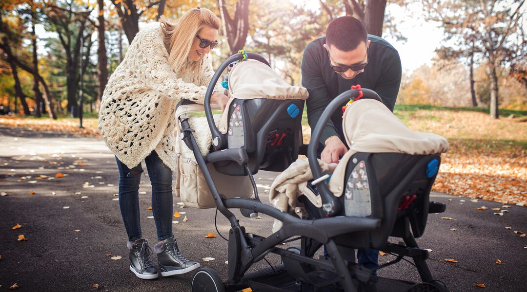 couple with double stroller in park