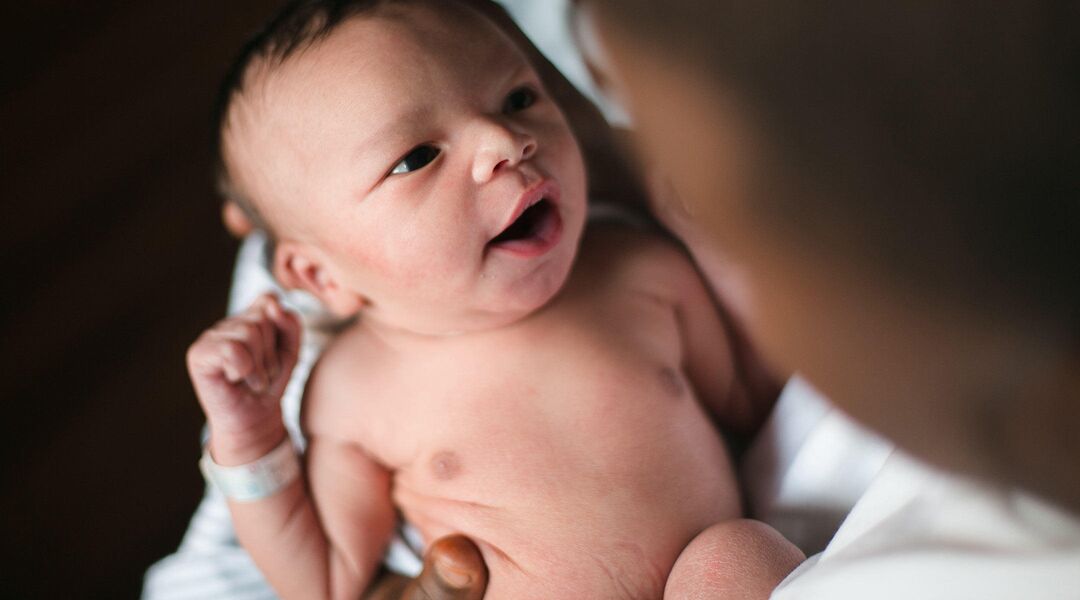emotional moment holding newborn after birth