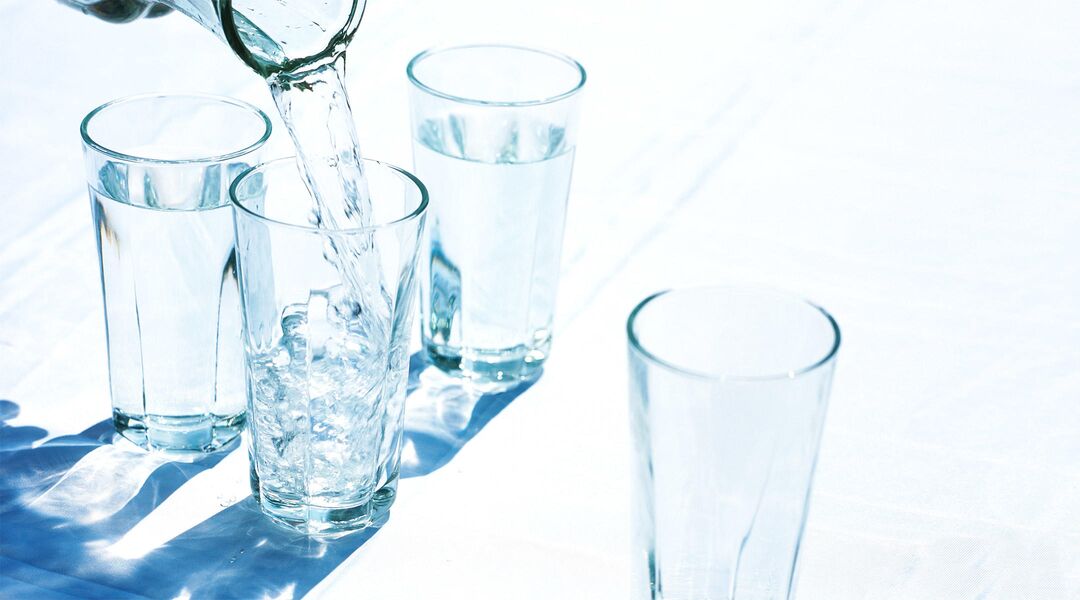 water pitcher pouring water into glasses