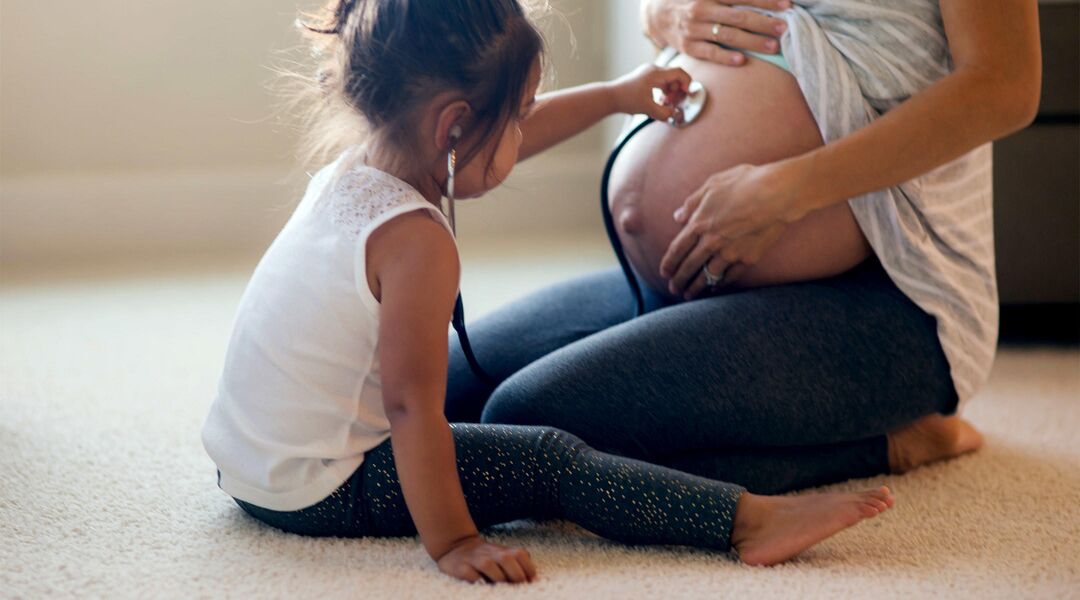 pregnant woman playing daughter