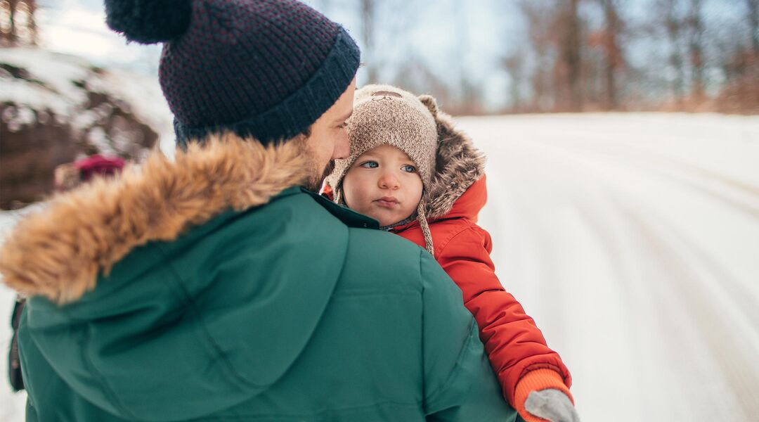 dad carrying baby in winter jacket
