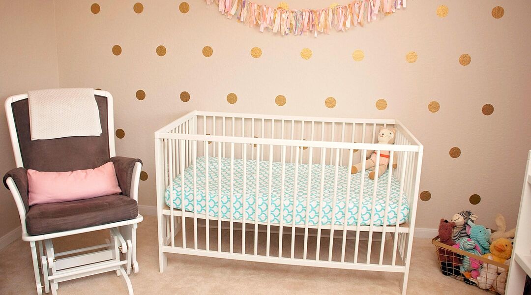 nursery crib and glider with polka dot wall decals
