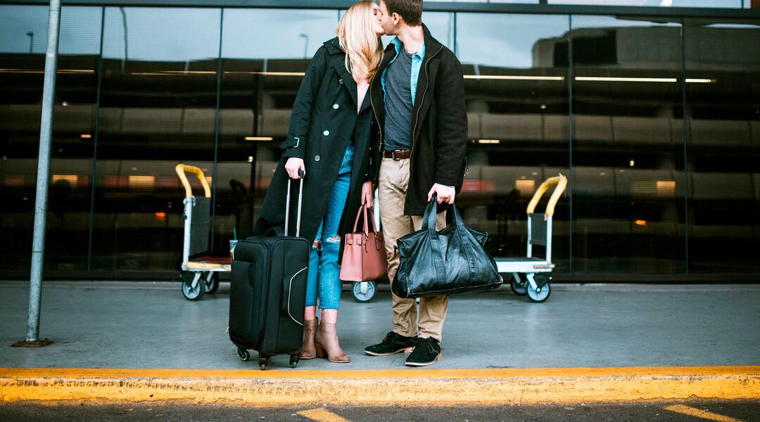 couple kissing at the airport during the holidays