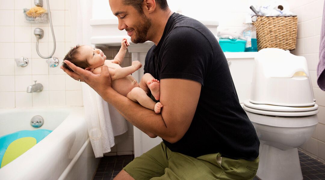 dad holding new baby after bath