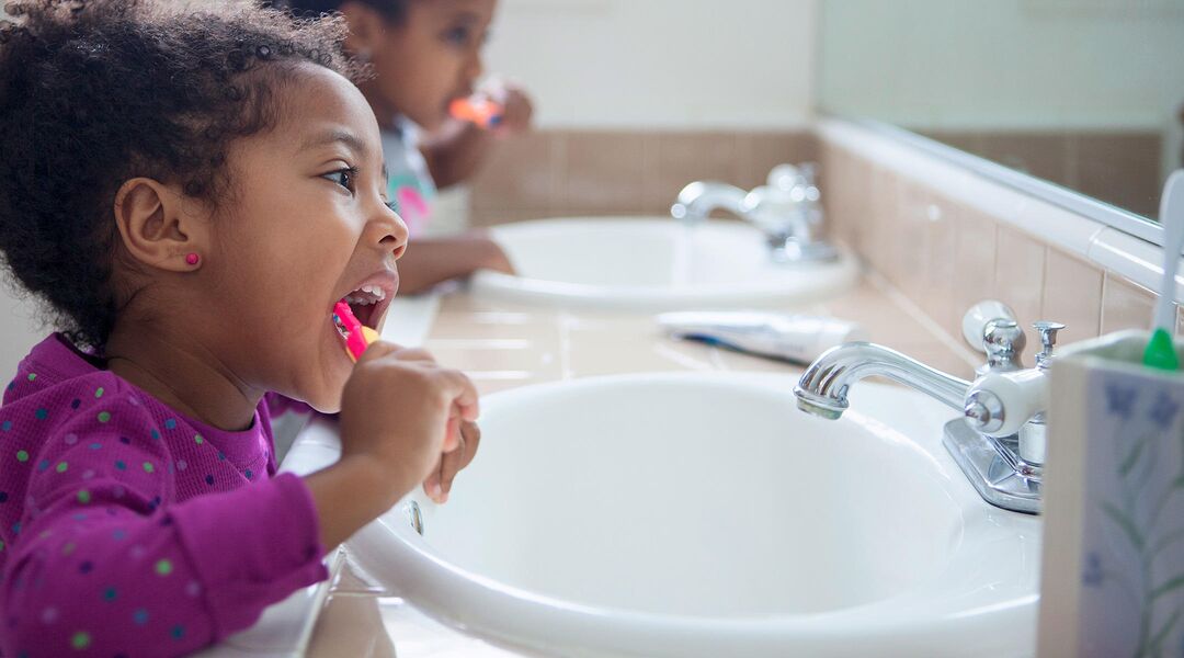 little girls learning to brush their teeth