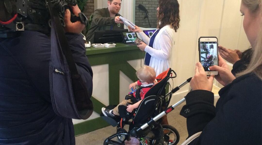 Mother and toddler in stroller buying medical marijuana