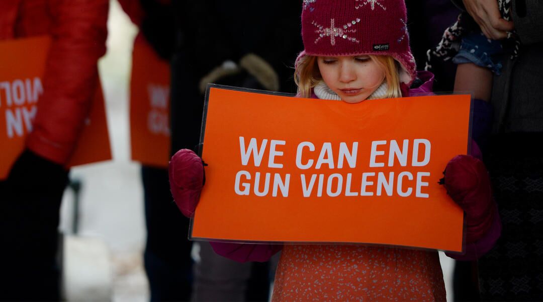 young girl holding sign protesting gun violence