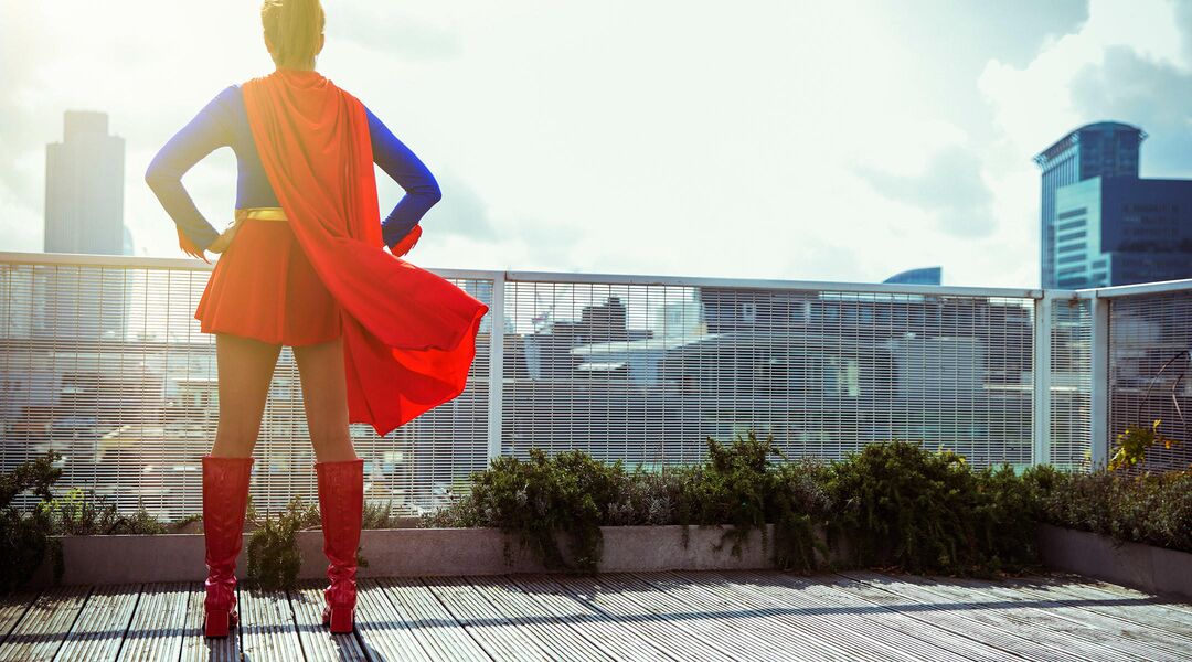 superhero mom standing on balcony with red cape