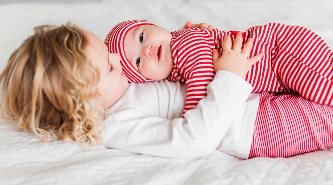 siblings embracing in holiday pajamas