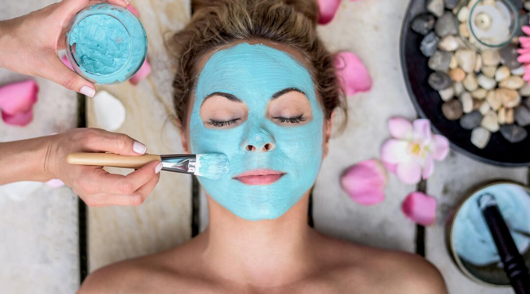 Woman getting a facial with a blue mask